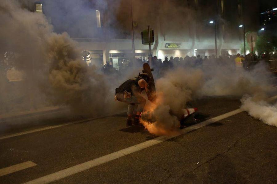 A protester protecting himself from tear gas with his skateboard while demonstrating against the death in Minneapolis police custody of African-American man George Floyd, and of Dion Johnson, who was killed in Arizona, outside of Phoenix police headquarters in Phoenix, Arizona, US on Friday. –Reuters Photo