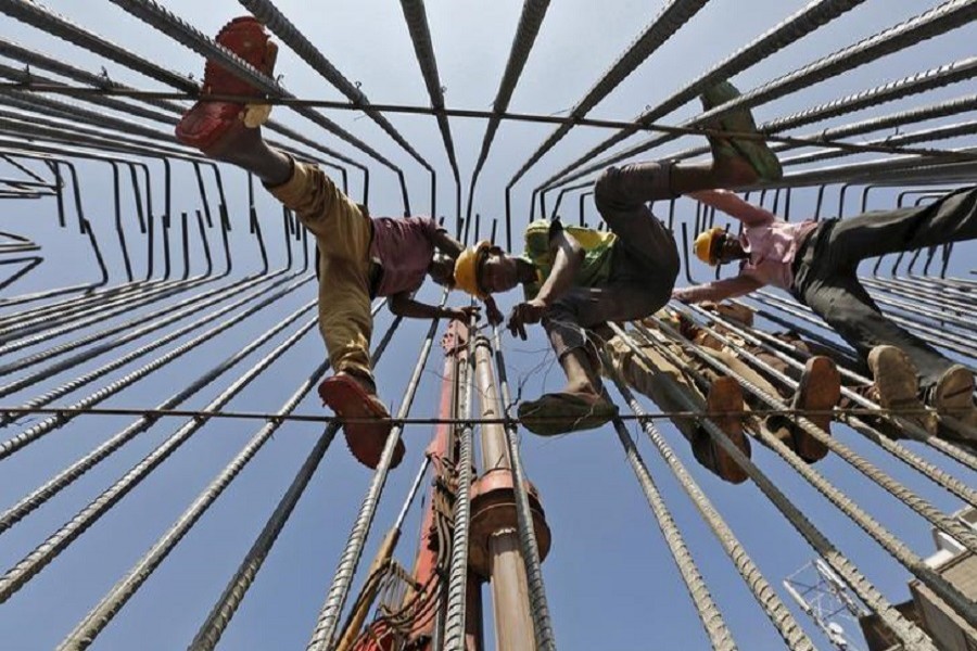 Labourers work at the construction site of an overhead road bridge in Ahmedabad, India, October 30, 2015. — Reuters/Files