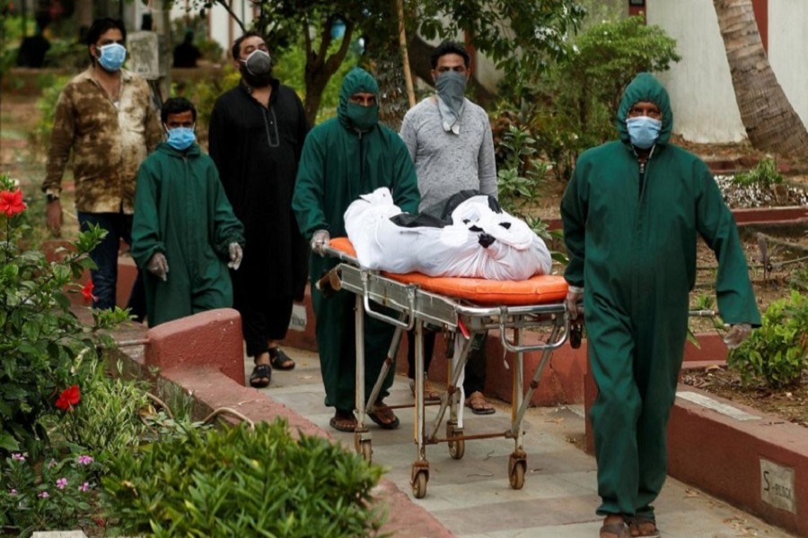 Volunteers carry the body of a victim, who died from the coronavirus disease (COVID-19), as relatives follow at a graveyard in Mumbai, India, June, 12, 2020. — Reuters