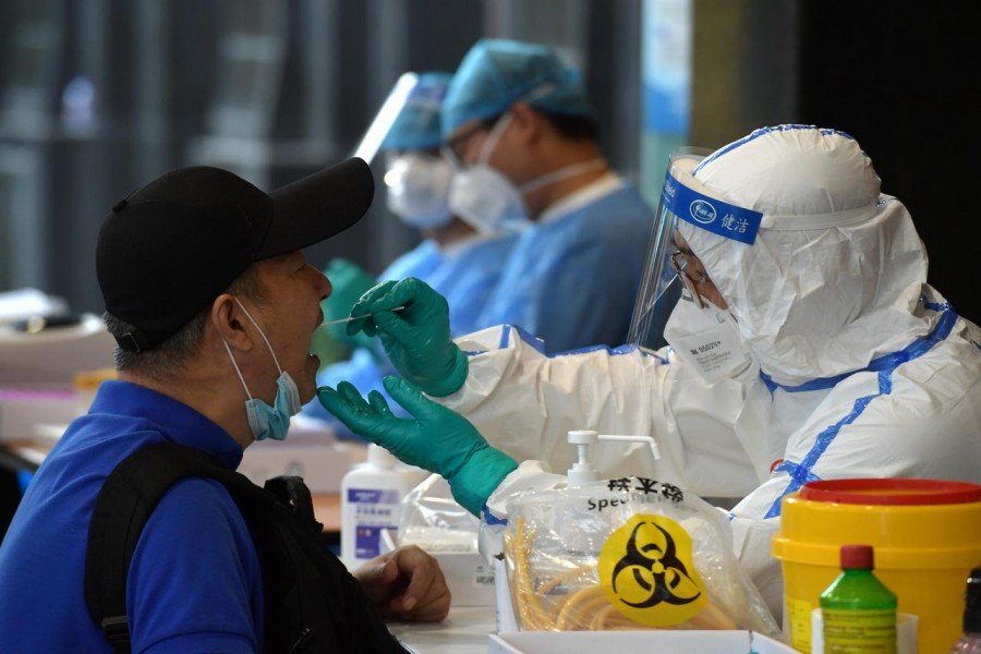 A medical staff in protective suit collects swabs from people who have recently travelled to Beijing for nucleic acid tests, following new cases of coronavirus disease (COVID-19) infections at the Chinese capital, in Nanjing, Jiangsu province, China on June 15, 2020 — China Daily via REUTERS