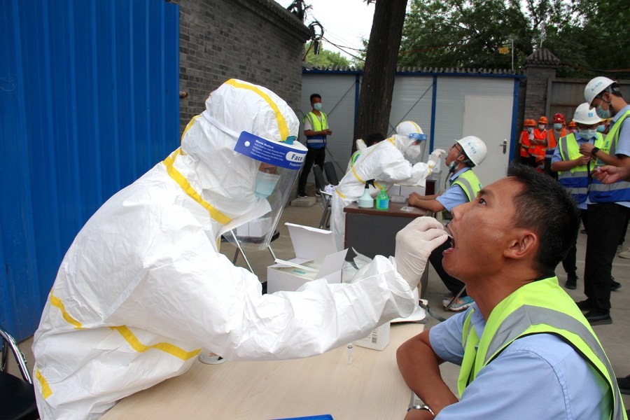 Medical workers collect throat swabs from construction workers at a construction site in Dongcheng District of Beijing, capital of China on June 17, 2020 — Xinhua photo