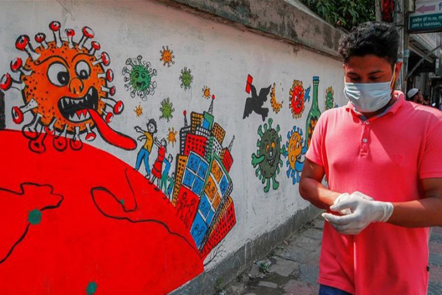 A man walks past graffiti about human fighting against the coronavirus in Narayanganj, Bangladesh, May 18, 2020. (Xinhua)