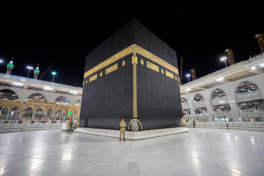 Saudi Arabian security officers stand in front of the Kaaba at an empty Grand Mosque, as a preventive measure against Covid-19 during the holy month of Ramadan, in the holy city of Mecca on May 5 — Saudi Press Agency/Handout via REUTERS