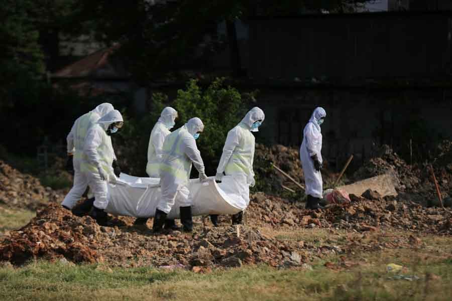 A group of workers bury a coronavirus victim at Khilgaon-Taltola graveyard in Dhaka. (AL JAZEERA)