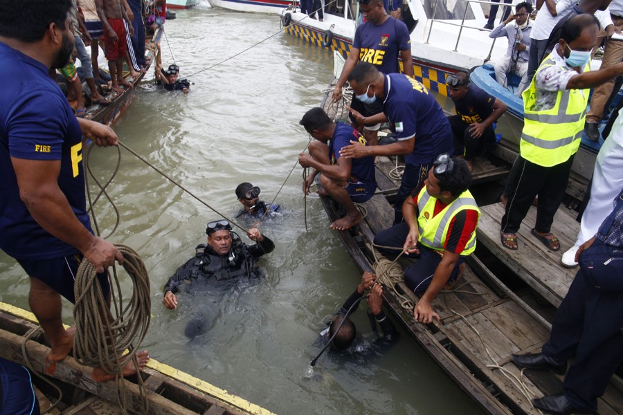 Divers from the Fire Services conducting rescue operations after a launch capsized in the Buriganga River in Dhaka on Monday