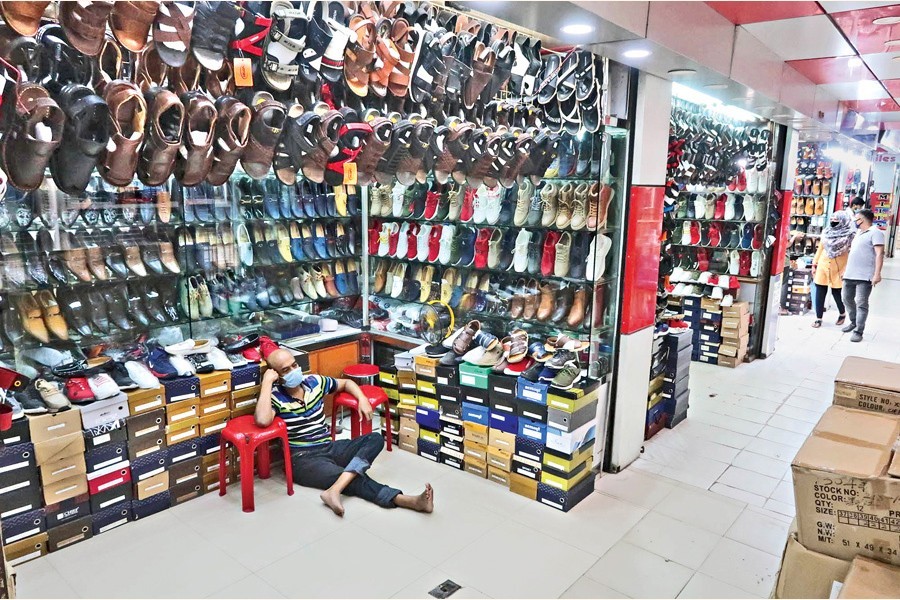 A salesman at a shoe shop in the city’s Polwel Super Market sits idle on Tuesday as the Covid-19 situation has put a damper on their bisiness --FE photo by Shafiqul Alam