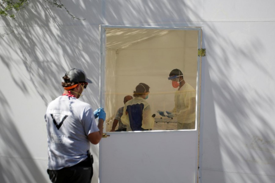 Medical staff from Global Response Management take samples from a patient suspected of contracting coronavirus disease (COVID-19) at an isolation area of a hospital installed at a migrant encampment, where more than 2,000 people live while seeking asylum in the U.S., in Matamoros, Mexico May 1, 2020. REUTERS/Daniel Becerril/File Photo