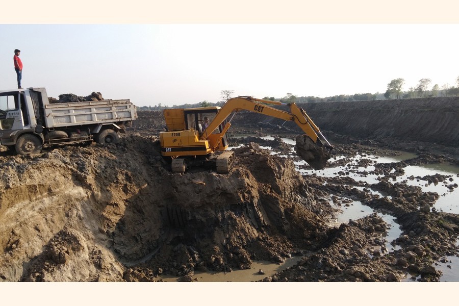 Topsoil being extracted by using a dredger illegally from a crop field in Rajbari. The practice is causing irrevocable harm to the district's agriculture for the past several years. — FE Photo