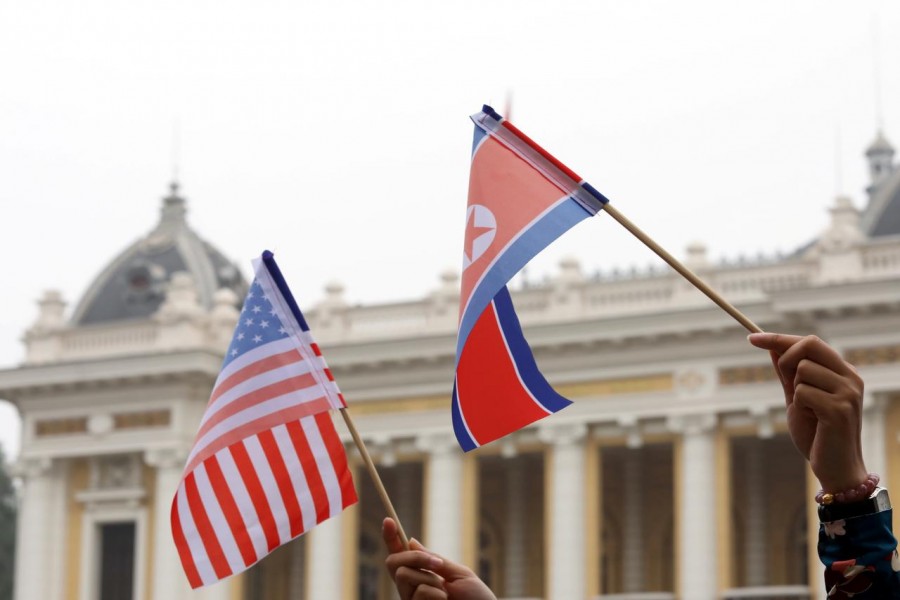 Residents hold US and North Korean flags while they wait for motorcade of North Korea's leader Kim Jong Un en route to the Metropole Hotel for the second US- North Korea summit in Hanoi, Vietnam February 28, 2019. REUTERS/Kham