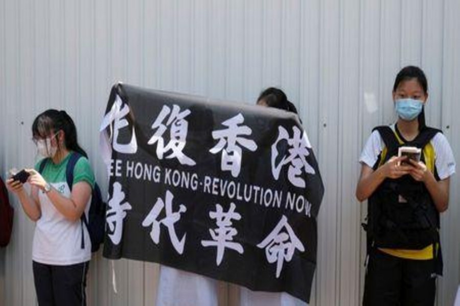 Secondary school students form a human chain near a school campus to protest against a teacher's release over 'her political beliefs' as they said, in Hong Kong, China June 12, 2020. REUTERS/Tyrone Siu