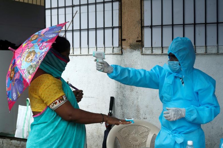 A healthcare worker checks the temperature and pulse of a resident during a check-up camp for the coronavirus disease (Covid-19), in Mumbai, India, July 04, 2020 — Reuters/Files