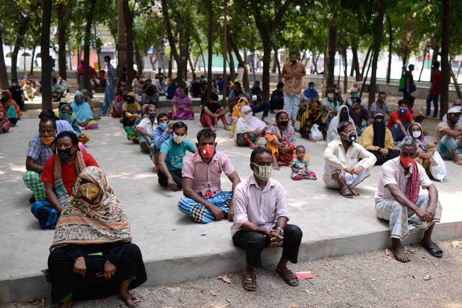 People waiting for relief supplies provided by local community in Dhaka a few months ago	—Al Jazeera Photo