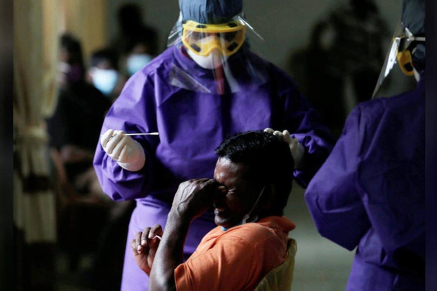 A man reacts as a health official uses a swab to collect a sample in a residential area, amid concerns over the spread of coronavirus disease (Covid-19) in Colombo, Sri Lanka on July 14, 2020 — Reuters photo