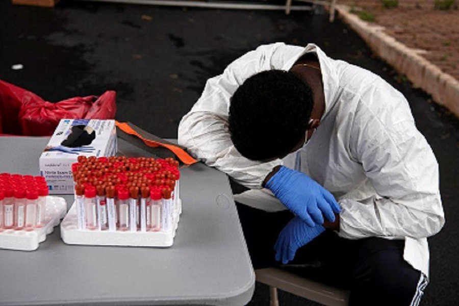 Overheated, a healthcare worker takes a break as people wait in their vehicles in long lines for the coronavirus disease (Covid-19) testing in Houston, Texas, US, July 07, 2020 — Reuters/Files