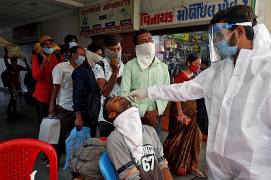 A healthcare worker wearing protective gear takes swab from a man for a rapid antigen test to tackle the coronavirus disease (Covid-19) outbreak, at a check-up point on a bus terminal in Ahmedabad, India, July 13, 2020 — Reuters/Files