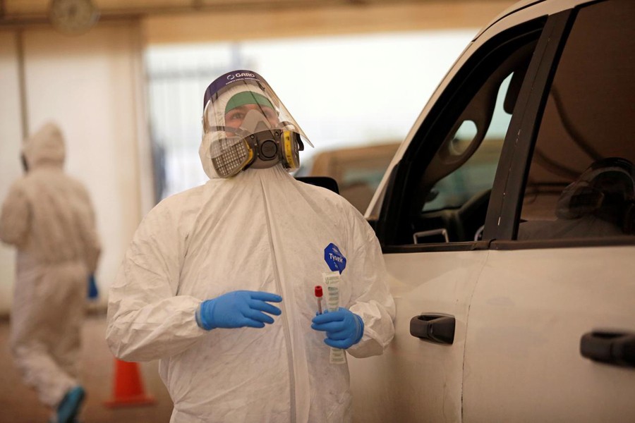 A healthcare worker explains a man how to lean back to collect a swab sample from him during test for the coronavirus disease (Covid-19), at a drive-thru testing site in Ciudad Juarez, Mexico July 17, 2020. REUTERS/Jose Luis Gonzalez