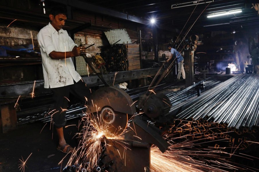 Workers make pipes used for drilling, at a factory in an industrial area in Mumbai, India — Reuters/Files