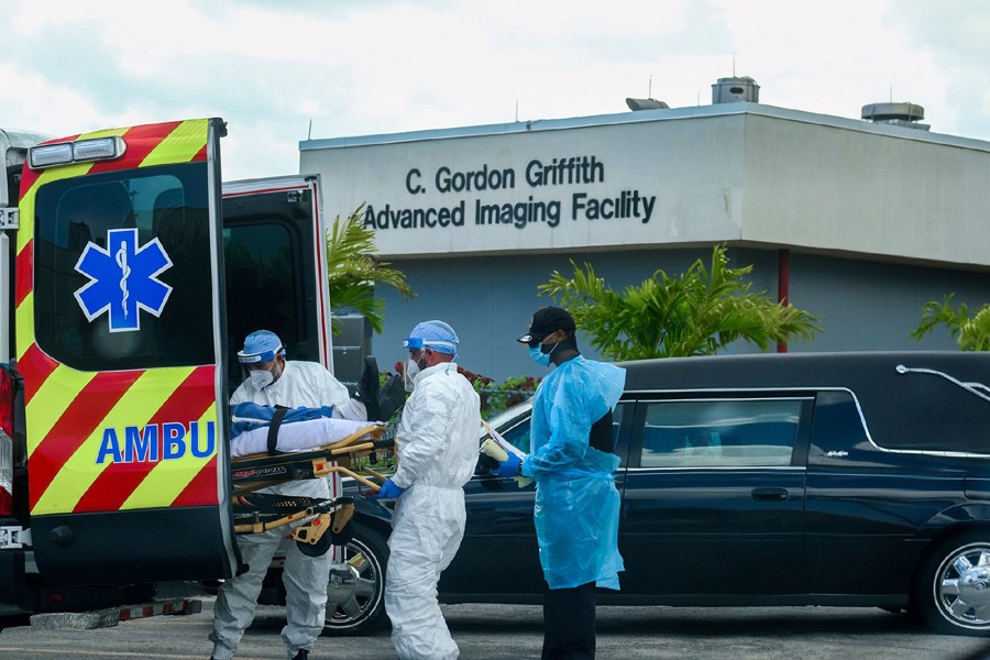 Emergency Medical Technicians (EMT) arrive with a patient while a funeral car begins to depart at North Shore Medical Center where the Covid-19 patients are treated, in Miami, Florida, US on July 14, 2020 — Reuters/Files