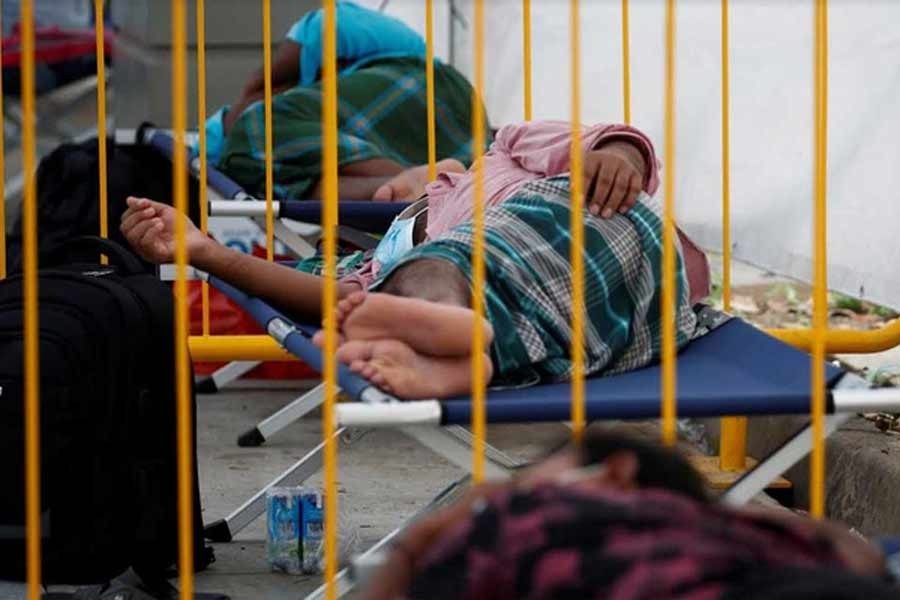 Migrant workers taking rest at a swab isolation facility as they wait for their test results at a dormitory, amid the coronavirus disease (COVID-19) outbreak in Singapore May 15, 2020 –Reuters Photo