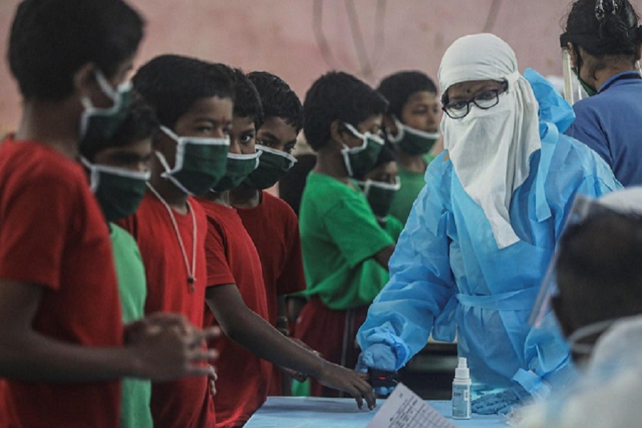 A health worker in personal protective equipment (PPE) checks the pulse of a child at a children's home during a checkup campaign for the coronavirus disease (Covid-19) in Mumbai, July 28, 2020 — Reuters/Files