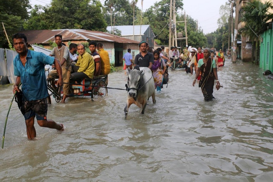 People move along a flooded road in Gaibandha, Bangladesh, July 18, 2019 — Reuters/Files