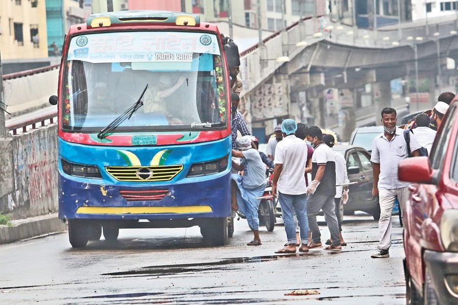 A bus that is carrying passengers without maintaining any health safety guidelines amid the coronavirus outbreak picks up a passenger from the middle of a road in Shantinagar area of Dhaka city, June 04, 2020 — FE/Files