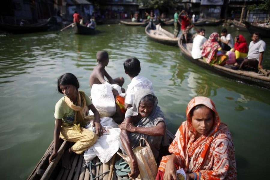 People cross a lake in a boat to reach Korail slum at Gulshan area in Dhaka, September 13, 2013 — Reuters/Files