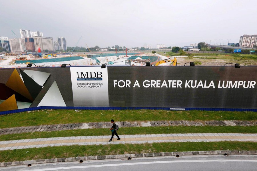 A man walks past a 1 Malaysia Development Berhad (1MDB) billboard at the funds flagship Tun Razak Exchange development in Kuala Lumpur on March 1, 2015 — Reuters/Files