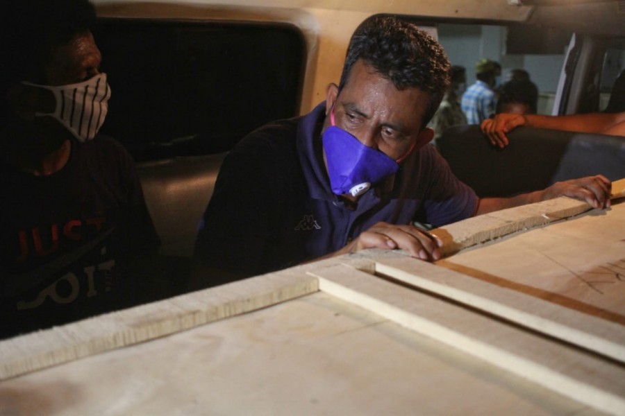 Relatives of a deceased sit in an ambulance with a coffin of their loved one - UNB photo