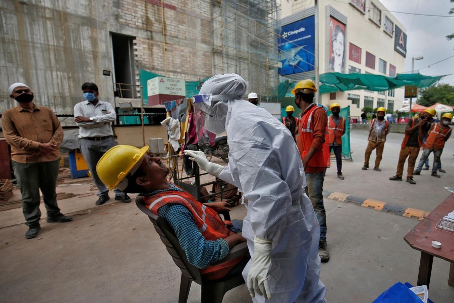 A healthcare worker wearing personal protective equipment (PPE) takes swab from a construction worker for a rapid antigen test at a construction site, amidst the coronavirus disease (COVID-19) outbreak, in Ahmedabad, India, on September 9, 2020 — Reuters photo