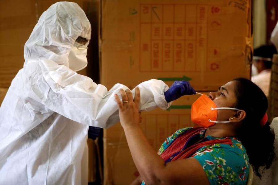 A health worker in personal protective equipment (PPE) collects a swab sample from a woman during a rapid antigen testing campaign for the coronavirus disease (Covid-19) in Mumbai, India on September 7, 2020 — Reuters/Files