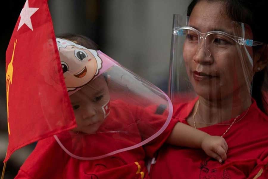 A mother and her son holding a flag of National League for Democracy party, amid coronavirus disease spread concerns during an election campaign rally in Yangon on September 8 –Reuters Photo