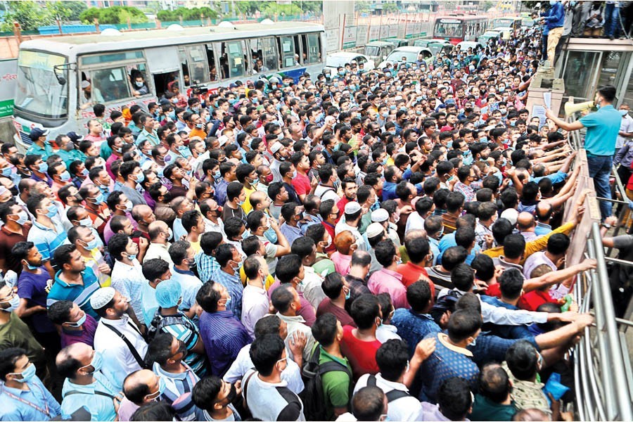 Migrant workers, outraged over not getting air tickets from Saudi Arabian Airlines office, stage a demonstration on the road in front of the Sonargaon Hotel in the city on Tuesday — FE photo by Shafiqul Alam