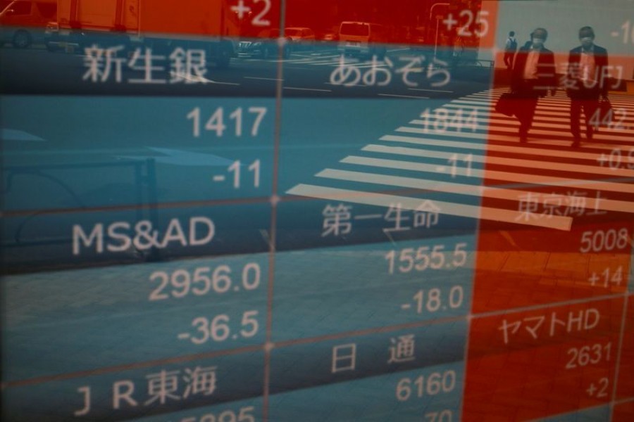 Passersby wearing protective face masks are reflected on a stock quotation board outside a brokerage, amid the coronavirus disease (COVID-19) outbreak, in Tokyo, Japan on September 17, 2020 — Reuters/Files