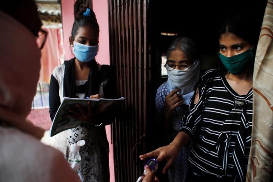 Community health volunteers check the pulse of a resident during a check-up campaign for the coronavirus disease (Covid-19) in Mumbai, India, September 30, 2020 — Reuters/Files