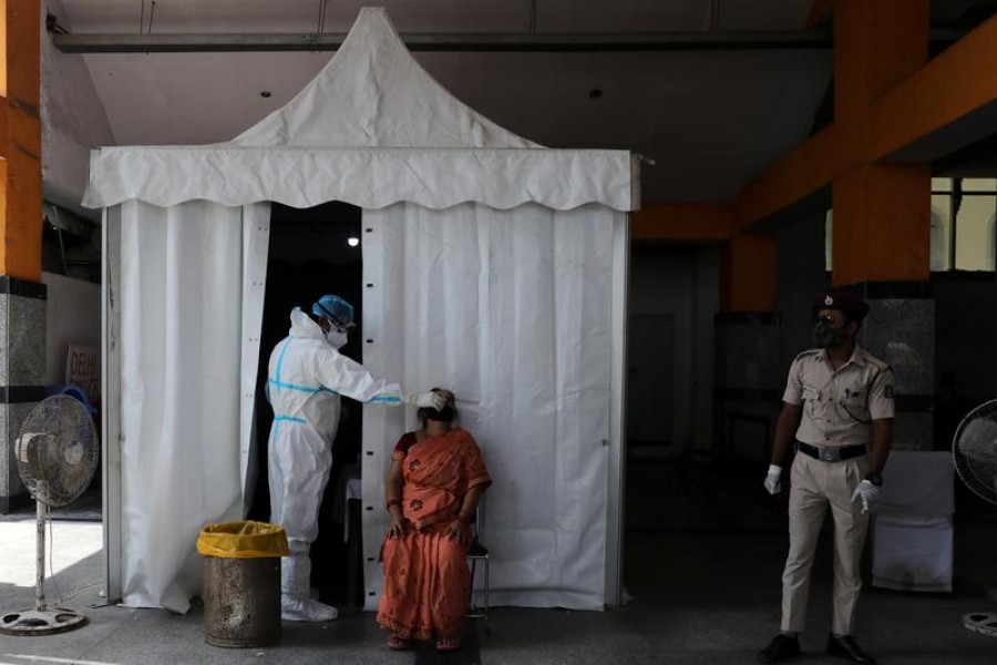 A healthcare worker wearing personal protective equipment (PPE) collects a swab sample from a woman, amid the spread of the coronavirus disease (COVID-19), in New Delhi, India, on September 29, 2020 — Reuters/Files