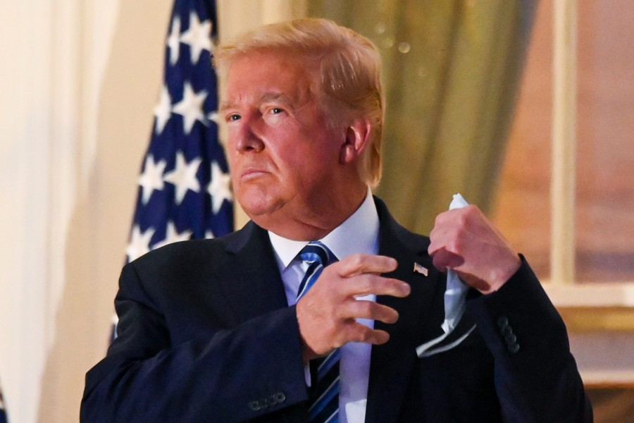 US President Donald Trump pulls off his protective face mask as he poses atop the Truman Balcony of the White House after returning from being hospitalised at Walter Reed Medical Center for coronavirus disease (Covid-19) treatment, in Washington, US on October 5, 2020 — Reuters photo