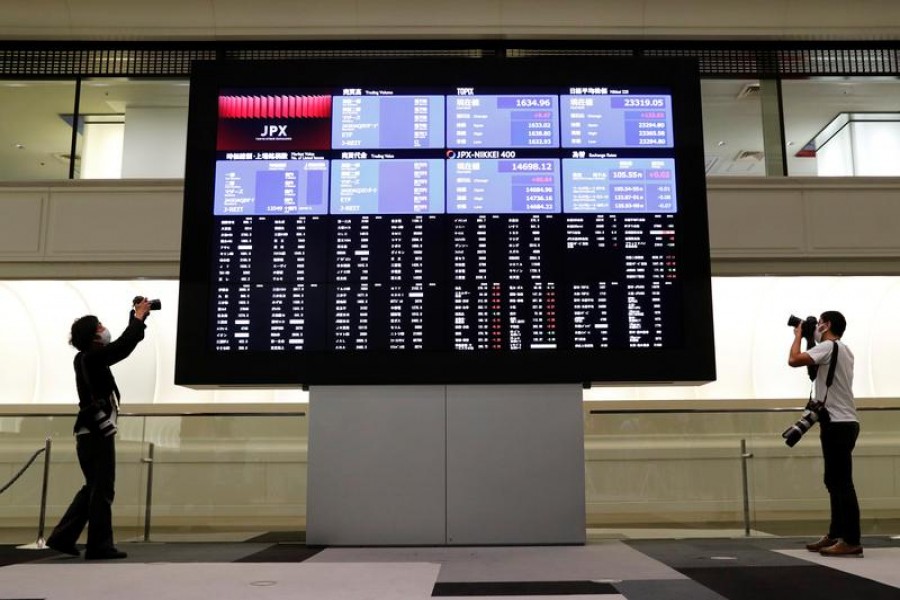 Photographers take photos near a large screen showing stock prices at the Tokyo Stock Exchange (TSE) after markets open in Tokyo, Japan, October 2, 2020 — Reuters/Files