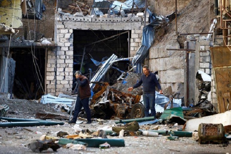 Men are seen among the ruins after recent shelling during the military conflict over the breakaway region of Nagorno-Karabakh, in Stepanakert, October 13, 2020 — Reuters