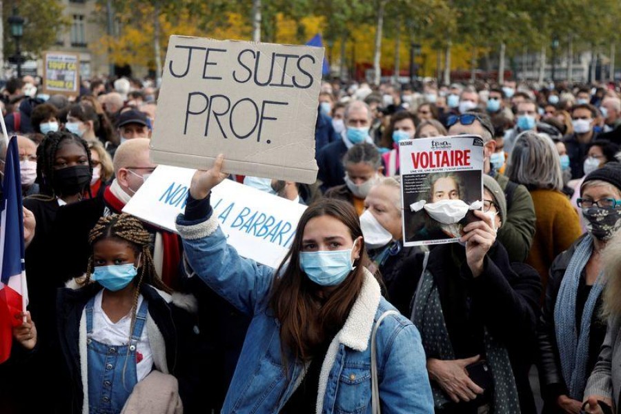 People gather at the Place de la Republique in Paris, to pay tribute to Samuel Paty, the French teacher who was beheaded on the streets of the Paris suburb of Conflans-Sainte-Honorine, France, October 18, 2020. Placard reads "I am a teacher". REUTERS/Charles Platiau