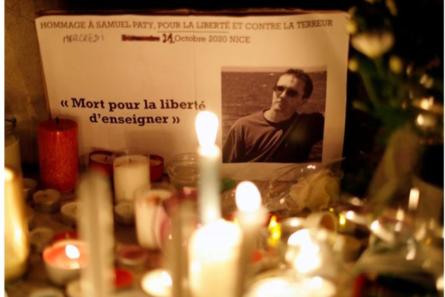 Candles are lit at a makeshift memorial as people gather to pay homage to Samuel Paty, the French teacher who was beheaded on the streets of the Paris suburb of Conflans-Sainte-Honorine, as part of a national tribute, in Nice, France, October 21, 2020. Reuters