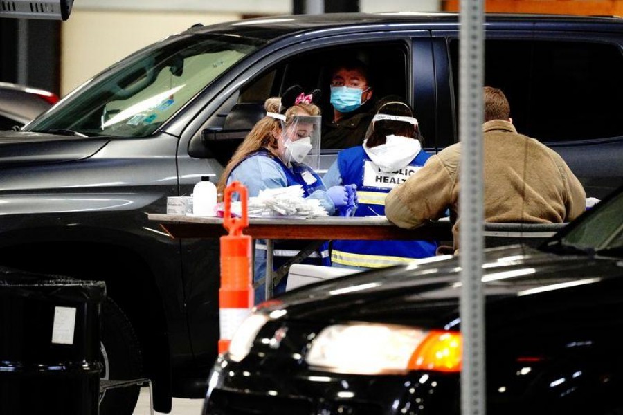 A healthcare worker wearing Minnie Mouse ears hairband works along another healthcare worker and a Wisconsin Army National Guard soldier at a drive-thru COVID-19 testing site inside the Alliant Energy Center complex, as the coronavirus disease (Covid-19) outbreak continues in Madison, Wisconsin, US on October 31, 2020 — Reuters/Files