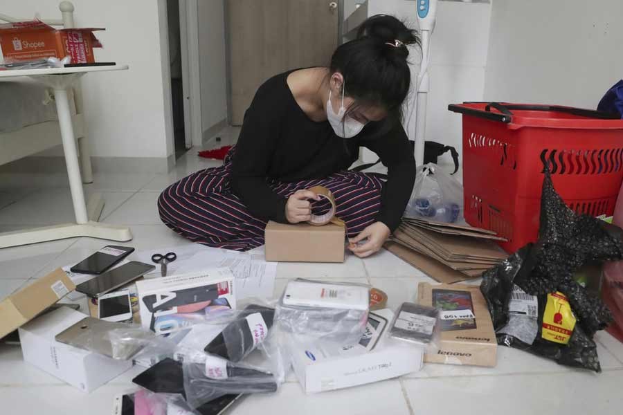 An Indonesian woman packing used mobile phones before shipping them to underprivileged children who lack internet access to study online, at her apartment in Tangerang of Indonesia in September –AP Photo