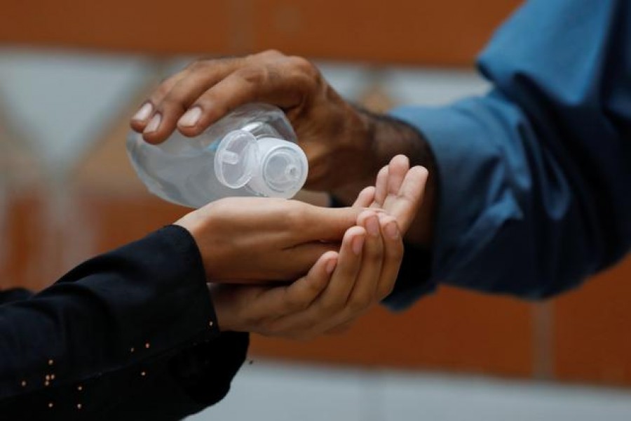 A student receives sanitiser before entering a class as schools reopen amid the coronavirus disease (Covid-19) pandemic, in Karachi, Pakistan, September 15, 2020 — Reuters/Files