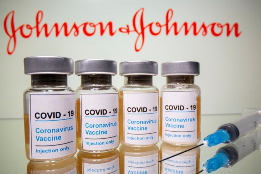 Vials with a sticker reading, "COVID-19 / Coronavirus vaccine / Injection only" and a medical syringe are seen in front of a displayed Johnson & Johnson logo in this illustration taken on October 31, 2020 — Reuters/Files