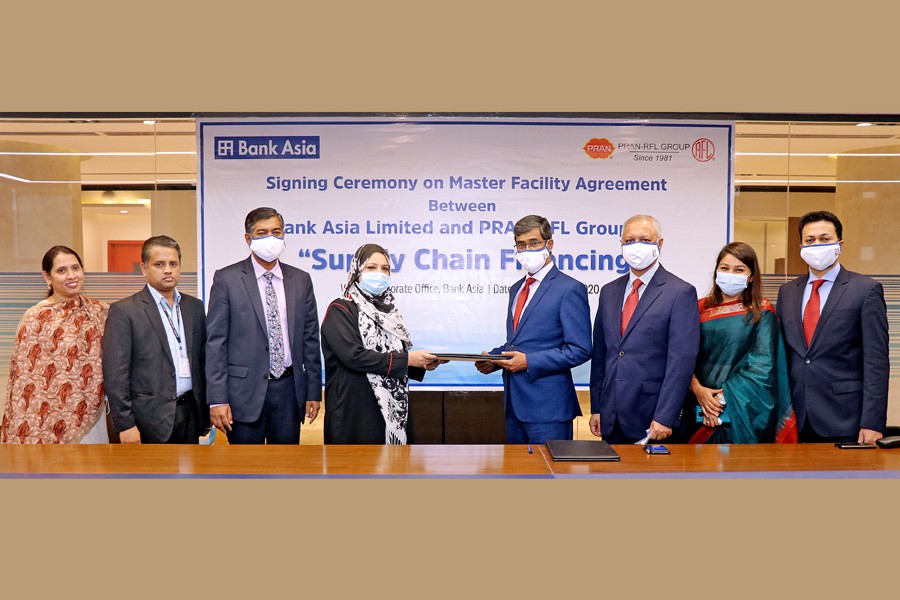 Mr Md Arfan Ali (fourth from right), President & Managing Director of Bank Asia Ltd and Ms Uzma Chowdhury (fourth from left), Director of PRAN-RFL Group seen exchanging documents on behalf of their respective organisations