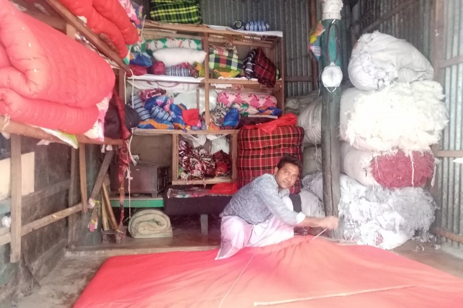 A quilt maker is busy making a quilt at a market in Netrokona district town area — FE Photo