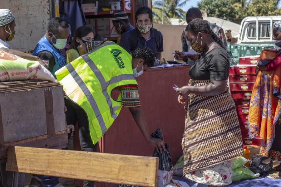 In this handout photo provided by the World Food Program on Tuesday, Sept. 22, 2020, a woman collects a monthly food parcel in Cabo Delgado Province, Mozambique, Thursday, Aug. 27, 2020.Falume Bachir/World Food Program via AP