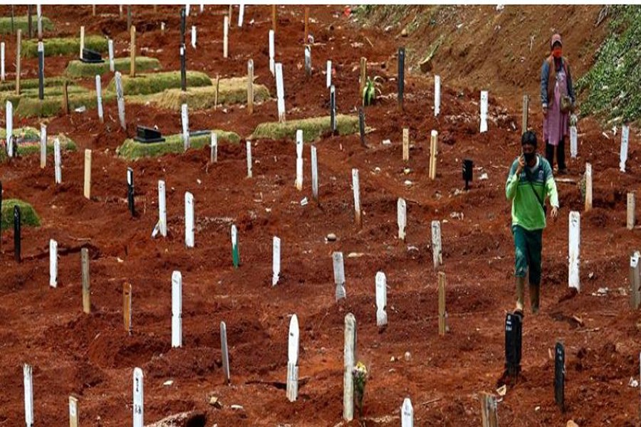 FILE PHOTO: A worker walks at the Muslim burial area provided by the government for victims of the coronavirus disease (COVID-19) at Pondok Ranggon cemetery complex in Jakarta, Indonesia, September 16, 2020. REUTERS/Ajeng Dinar Ulfiana/File Photo