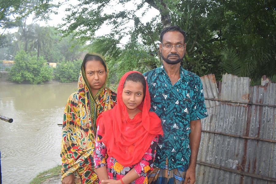 Farmer Faruk Hossain, who is moving from Chakla village to the city of Khulna with his wife Farida Yasmin and daughter. Photograph: Rafiqul Islam Montu/The Guardian